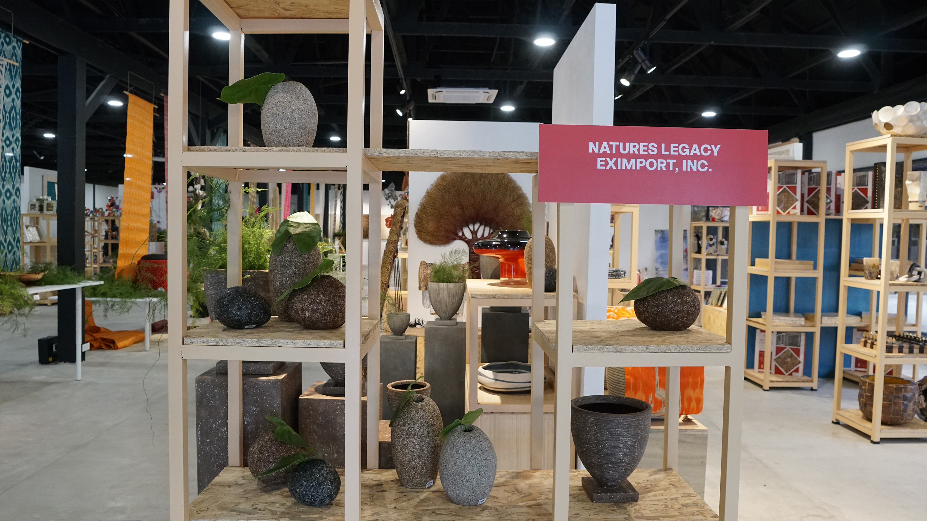Shelves displaying grey and brown stone-textured planters and vases by Nature's Legacy.