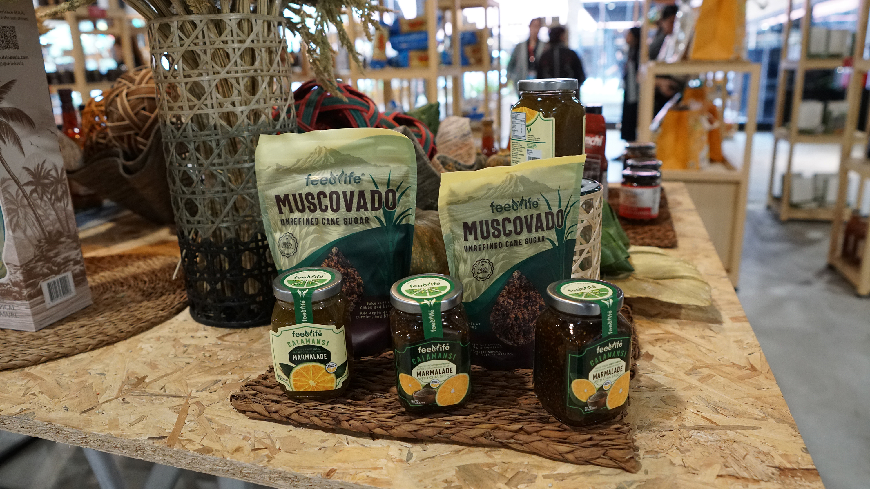 Packs of Muscovado sugar and jars of Calamansi Marmalade displayed on a woven mat.